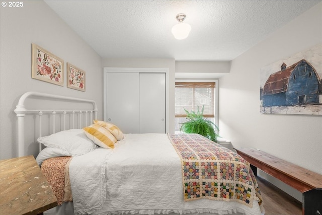 bedroom featuring a closet, a textured ceiling, and wood finished floors