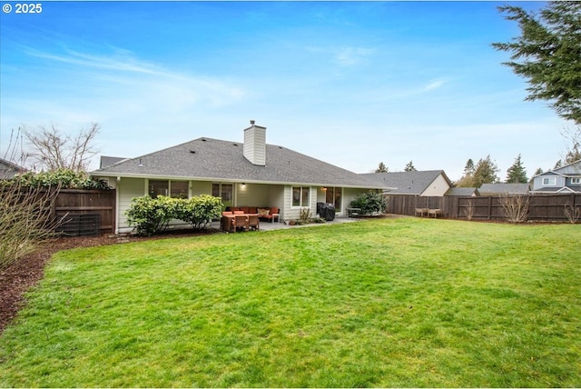 back of house featuring a yard, a chimney, a patio area, and a fenced backyard