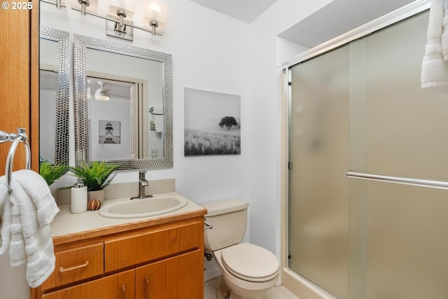 bathroom with a shower with door, vanity, and toilet