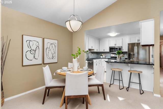 carpeted dining space with vaulted ceiling and sink