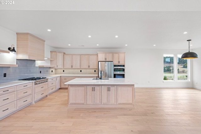 kitchen featuring hanging light fixtures, light brown cabinets, stainless steel appliances, and light hardwood / wood-style floors