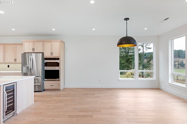 kitchen with plenty of natural light, wine cooler, light wood-type flooring, and appliances with stainless steel finishes