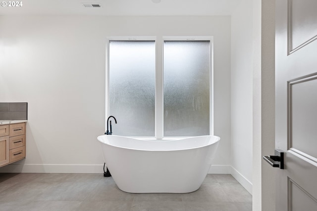 bathroom featuring vanity, tile patterned floors, and a bathtub