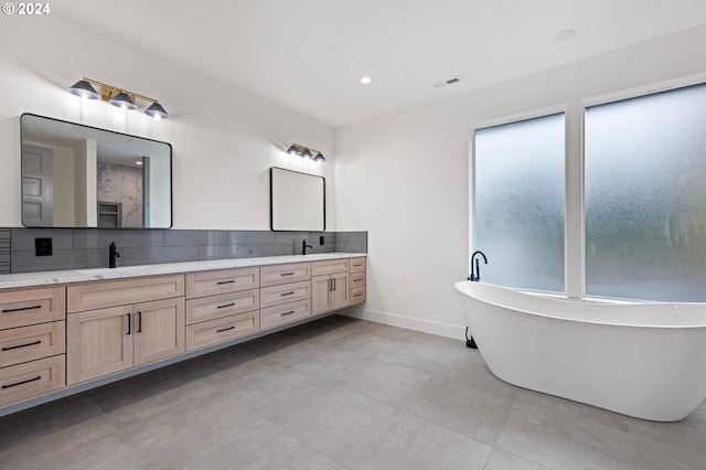 bathroom with backsplash, a washtub, and vanity