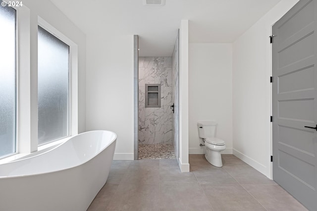 bathroom featuring tile patterned flooring, toilet, plenty of natural light, and independent shower and bath