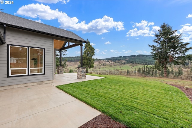 view of yard with a mountain view and a patio