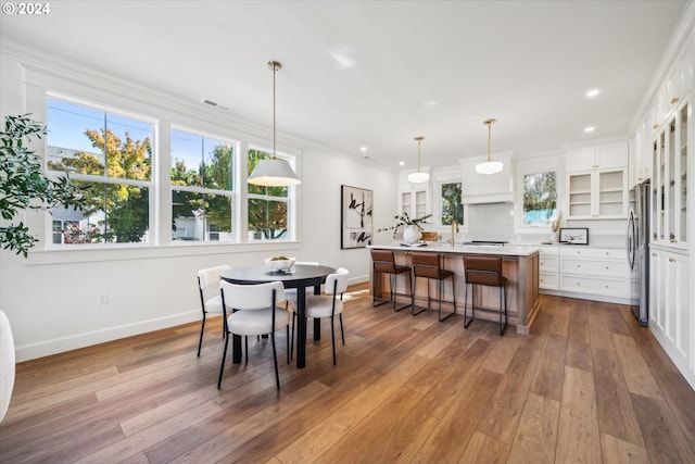 dining space with ornamental molding, visible vents, baseboards, and wood finished floors