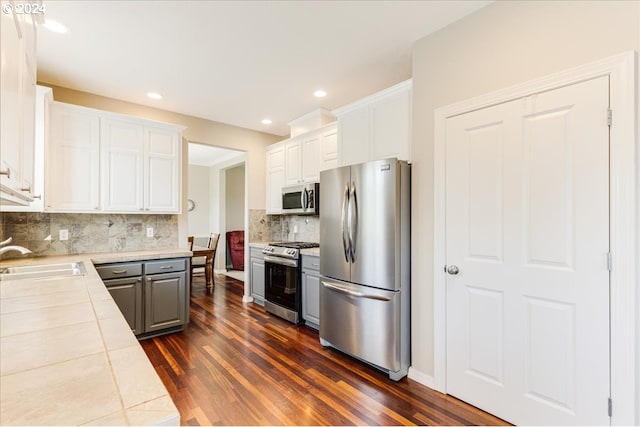 kitchen featuring dark wood-type flooring, white cabinets, sink, and stainless steel appliances