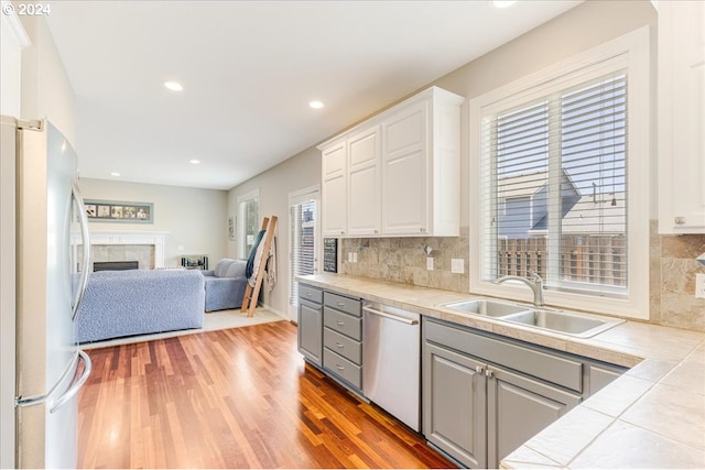 kitchen featuring dishwasher, tile countertops, a healthy amount of sunlight, and white refrigerator