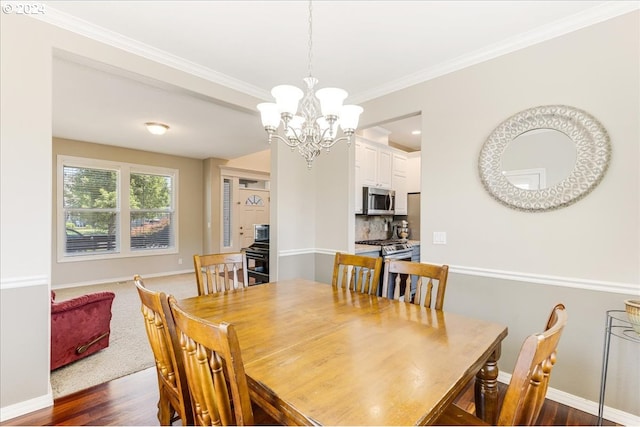 dining area featuring dark wood-type flooring, a chandelier, and crown molding