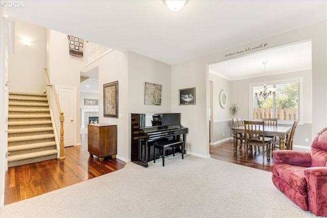 living room featuring an inviting chandelier, hardwood / wood-style flooring, and crown molding