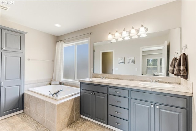 bathroom featuring vanity and tiled tub