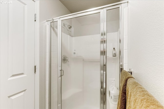 bathroom featuring a shower with door