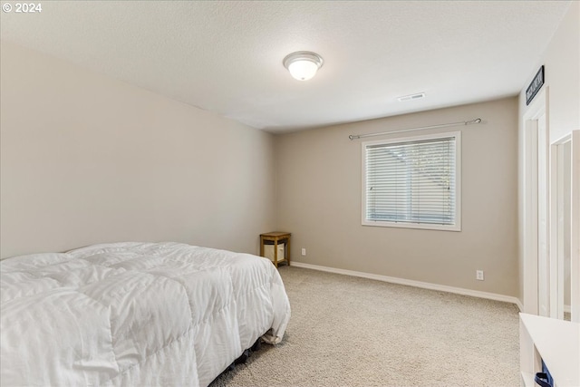 bedroom featuring a textured ceiling and carpet flooring