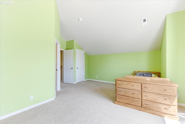 bedroom with lofted ceiling and light carpet