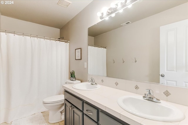 bathroom featuring decorative backsplash, tile patterned flooring, vanity, and toilet