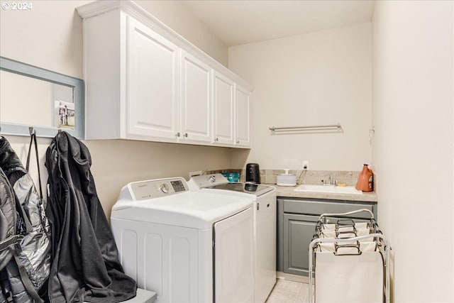 clothes washing area with washing machine and dryer, cabinets, sink, and light tile patterned floors