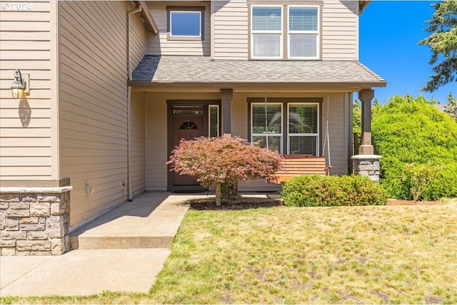 entrance to property with a lawn and covered porch