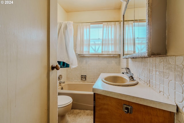 bathroom with vanity, a tub to relax in, toilet, and backsplash