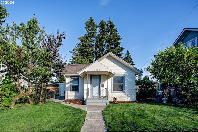 bungalow-style house featuring a front lawn