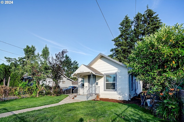 bungalow-style home with a front lawn