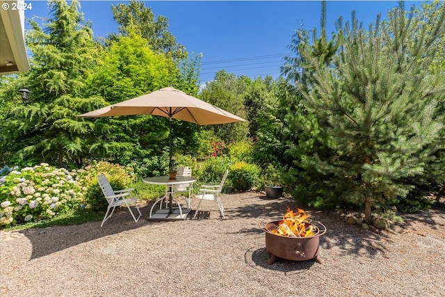 view of yard featuring an outdoor fire pit and a patio