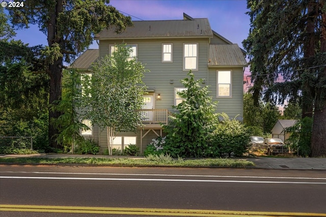 property exterior at dusk featuring a balcony