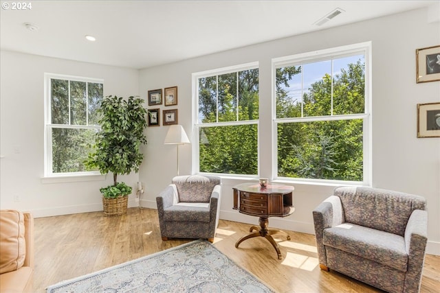 living area with light wood-type flooring and a healthy amount of sunlight