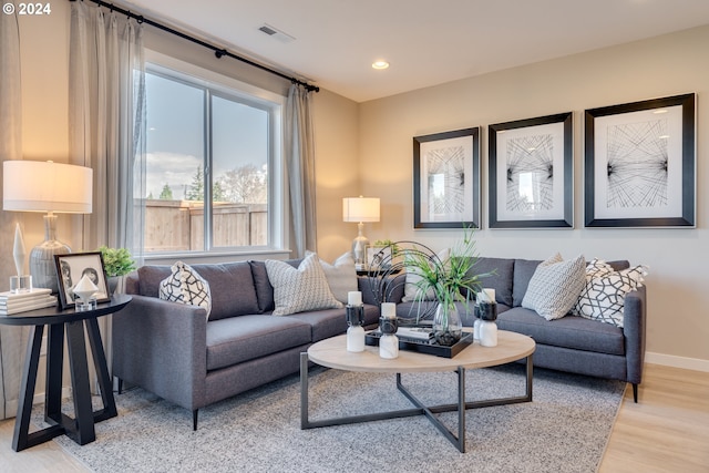 living area with light wood-type flooring, visible vents, baseboards, and recessed lighting