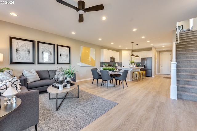 living room featuring stairway, recessed lighting, light wood-style floors, and ceiling fan