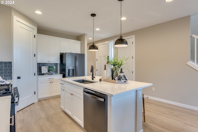 kitchen with a sink, stainless steel dishwasher, decorative backsplash, gas range, and black refrigerator with ice dispenser