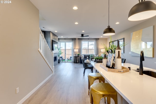 kitchen featuring decorative light fixtures, recessed lighting, light wood-type flooring, and a sink