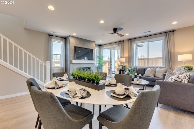 dining area featuring recessed lighting, stairs, a fireplace, and light wood finished floors