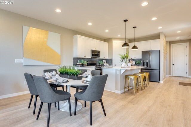 dining area featuring recessed lighting, baseboards, and light wood-style flooring