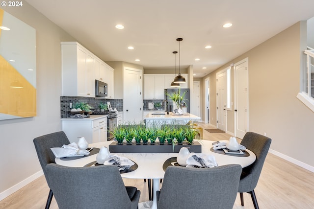 dining room featuring recessed lighting, light wood-style floors, and baseboards