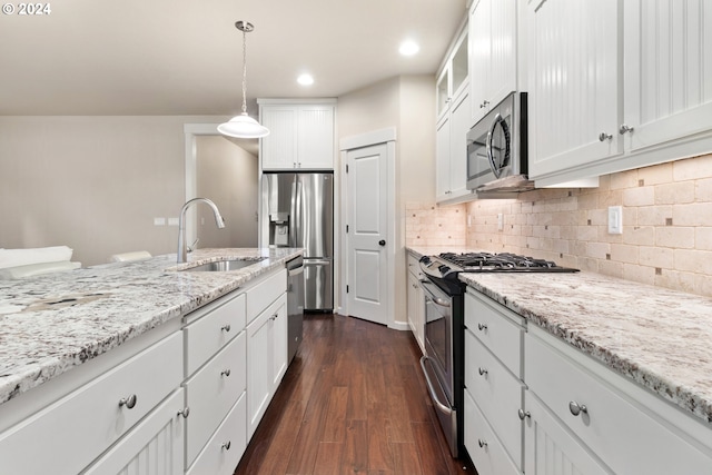 kitchen featuring white cabinets, sink, dark hardwood / wood-style floors, decorative light fixtures, and stainless steel appliances