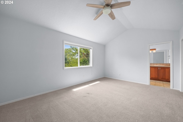 carpeted empty room with ceiling fan and vaulted ceiling