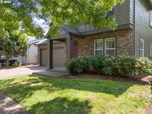 view of front of home with a front yard and a garage