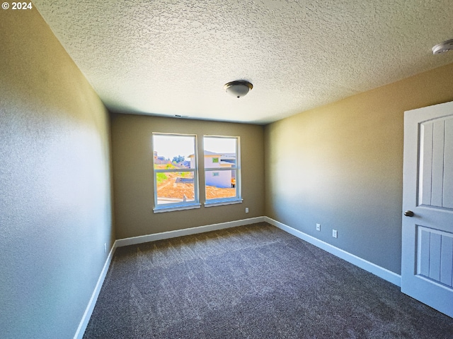 carpeted empty room featuring a textured ceiling