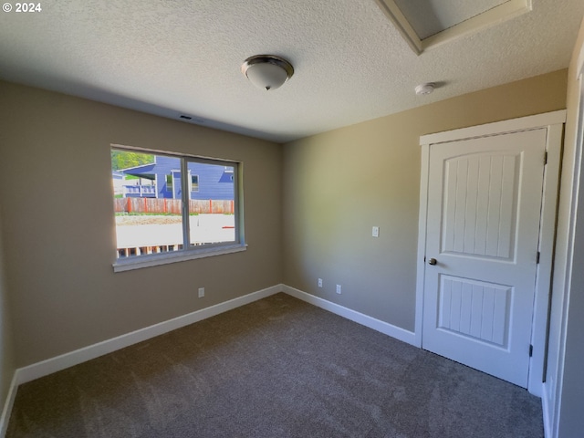 carpeted empty room featuring a textured ceiling