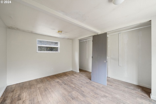 unfurnished bedroom featuring light hardwood / wood-style flooring and a closet