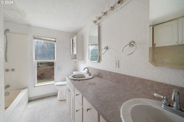 bathroom with vanity, a textured ceiling, and toilet