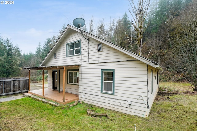 rear view of property with a yard and a deck