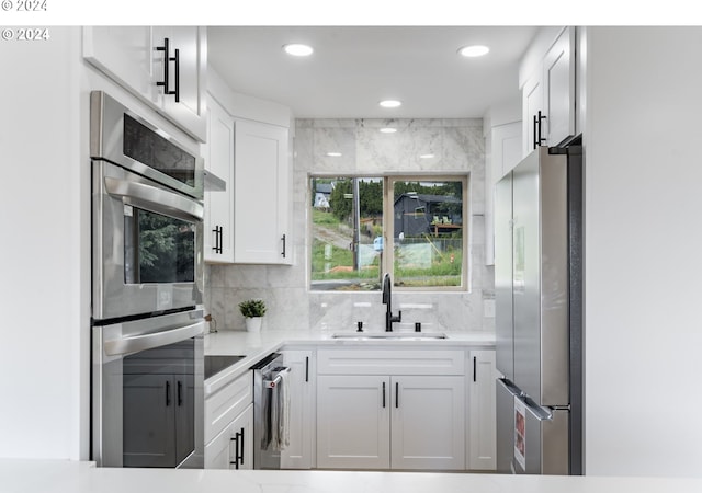 kitchen with sink, white cabinets, and appliances with stainless steel finishes