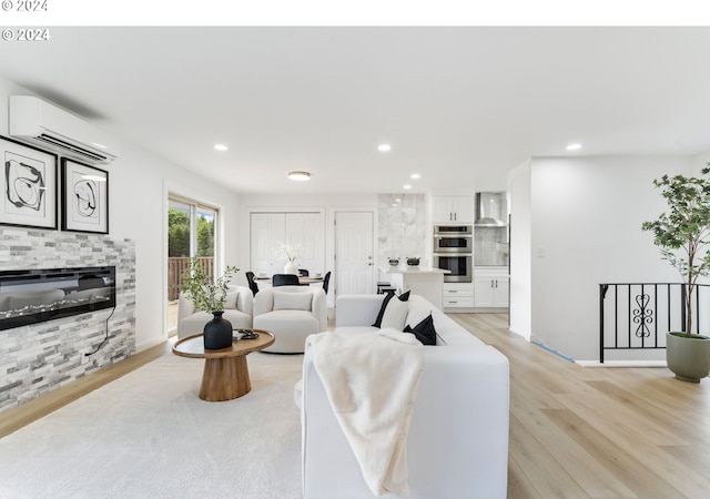 living room featuring light wood-type flooring and a wall unit AC