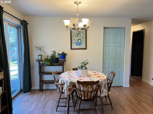 dining space featuring wood-type flooring and a chandelier