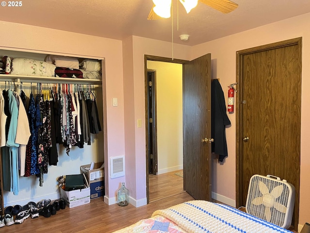 bedroom featuring ceiling fan, a closet, and light hardwood / wood-style floors