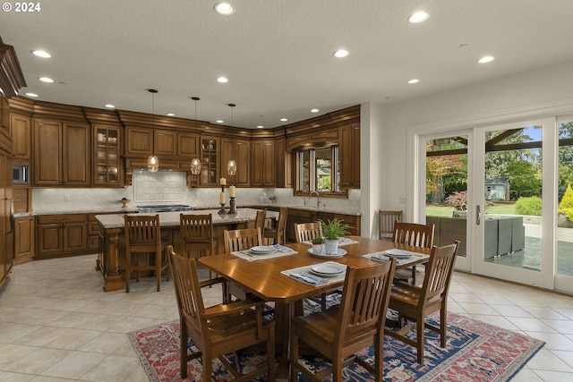 dining space featuring sink and light tile patterned floors