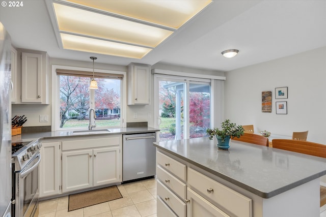 kitchen featuring sink, light tile patterned floors, stainless steel appliances, and plenty of natural light