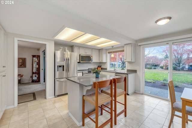 kitchen featuring light tile patterned flooring, sink, a kitchen island, and stainless steel appliances